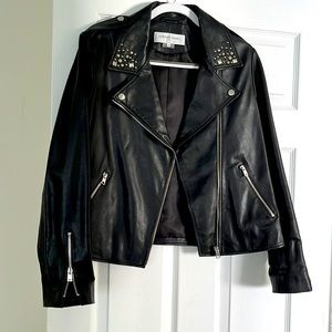 Leather motorcycle style jacket with studs on collar & zippers at sleeve cuffs.